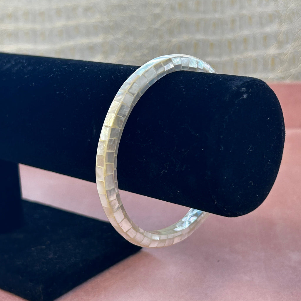 Silver ring on a black jewelry stand with a blurred background